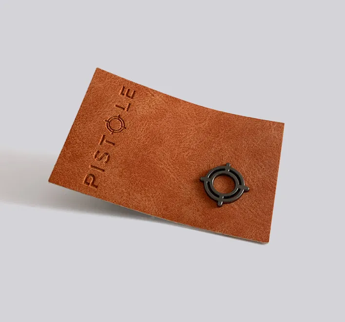 Pistole leather label with metal trim.